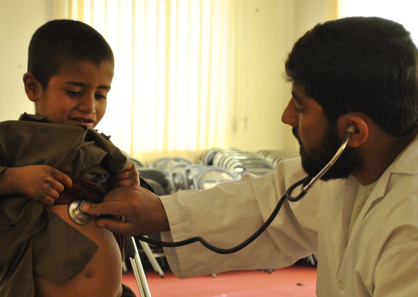 A doctor examining a young patient with a stethoscope